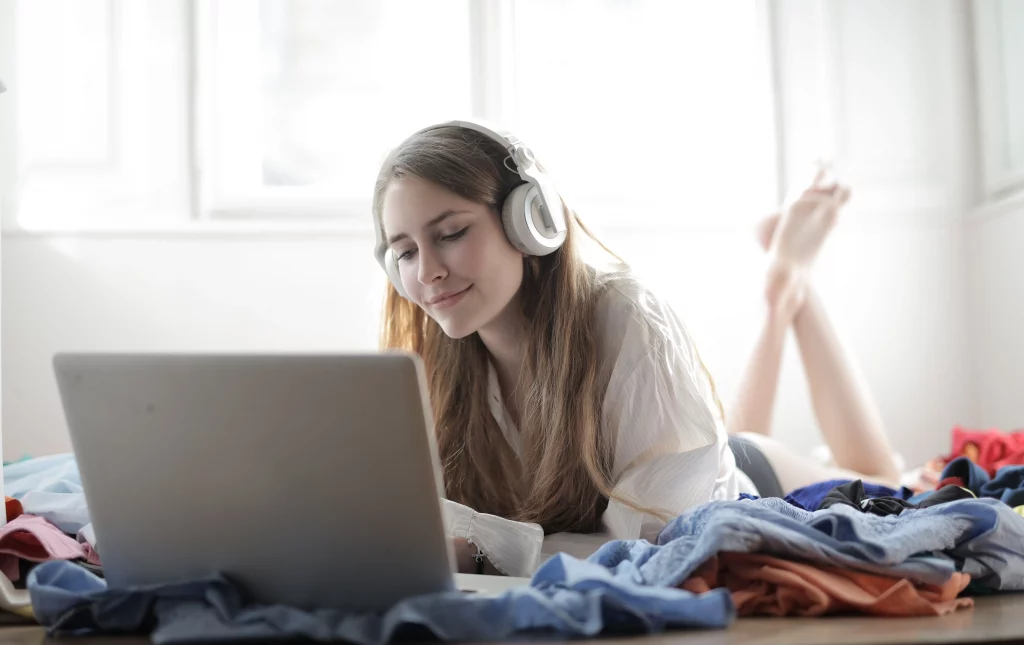 woman listening with headphones and laptop